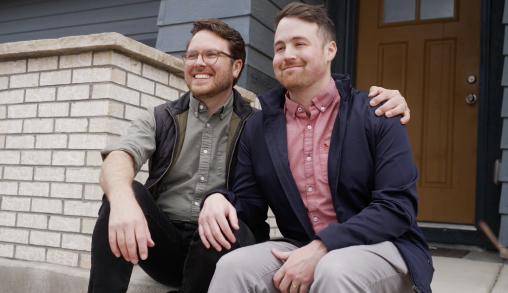 2 men smiling at the camera on their front step.