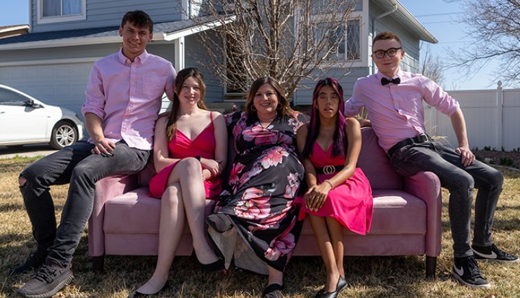 Group of teenagers dressed up in red and pinks outside on a couch.