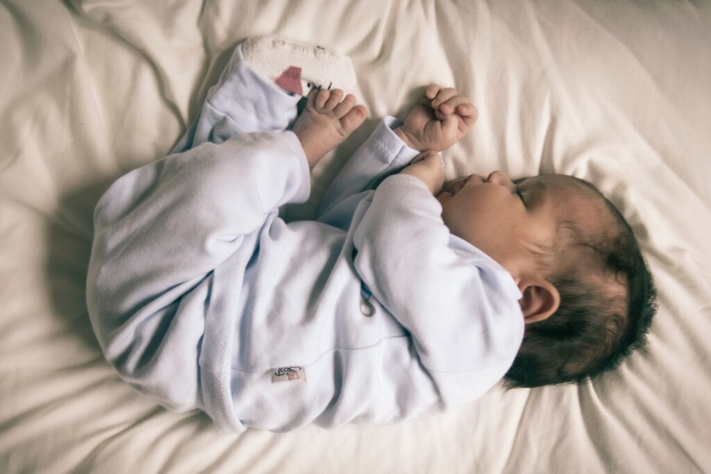 Infant sleeping on bed.