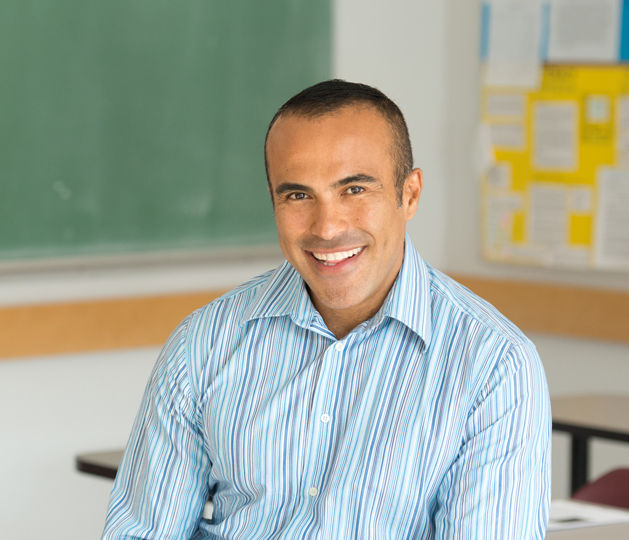 Un profesor sonriendo en un aula.