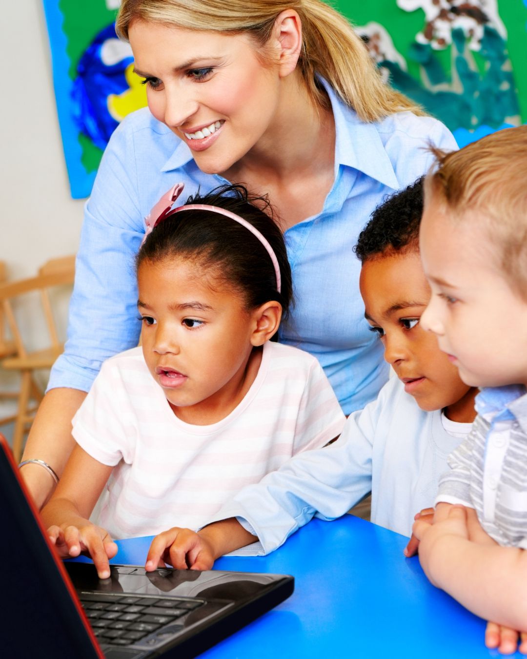 Mujer y tres niños mirando la computadora