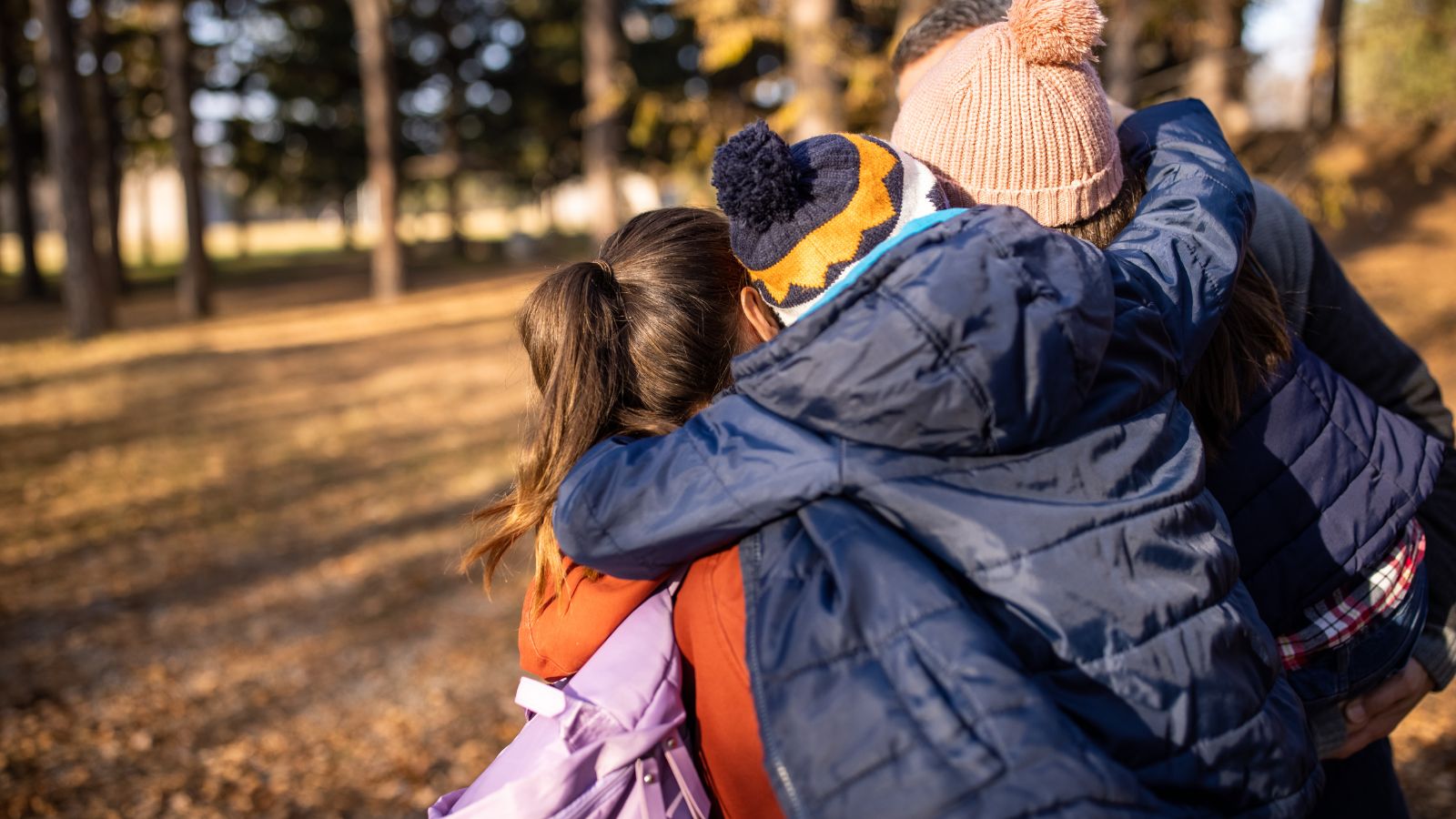 Family of four hugging in a park