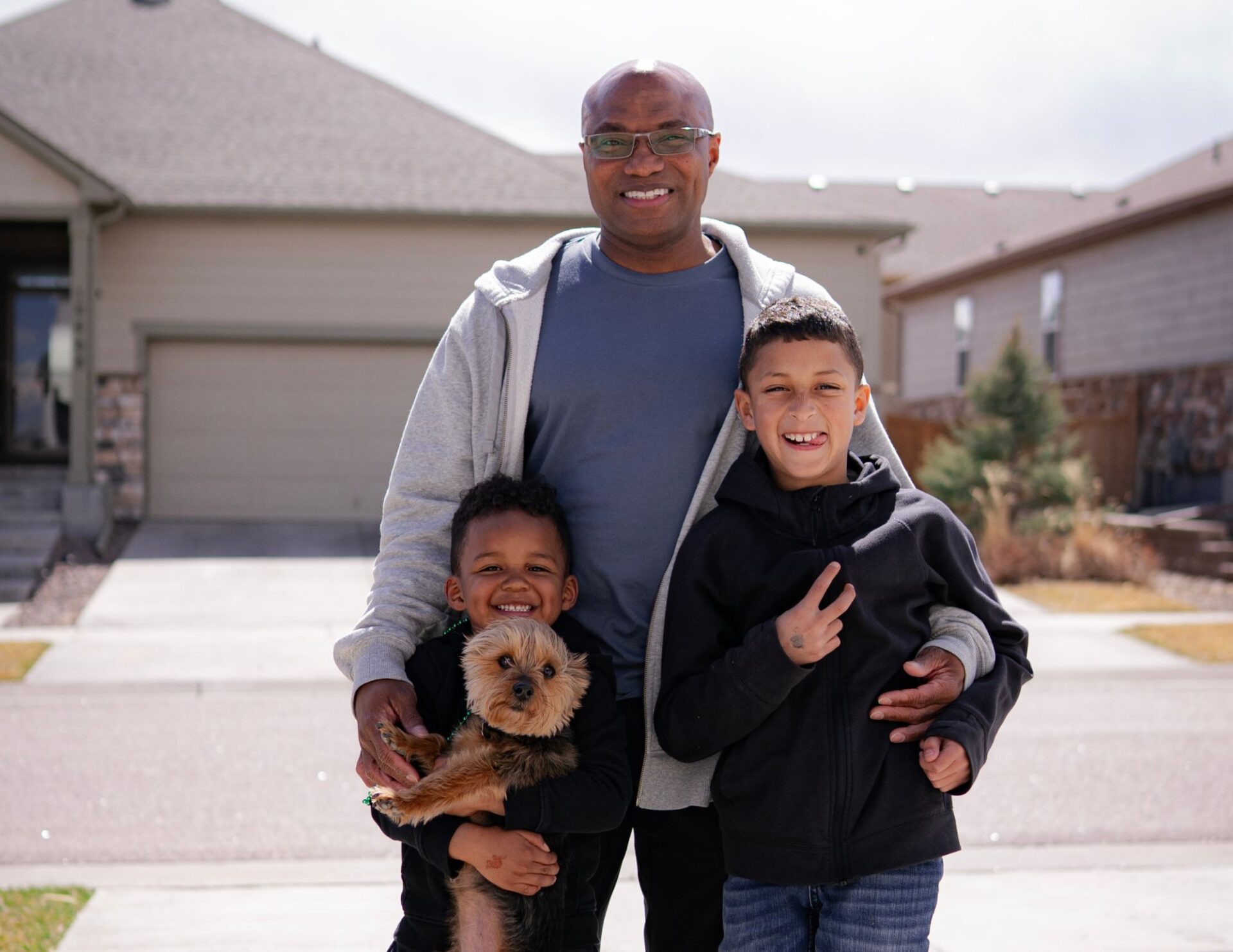 A dad with his two young adopted sons and the family dog.