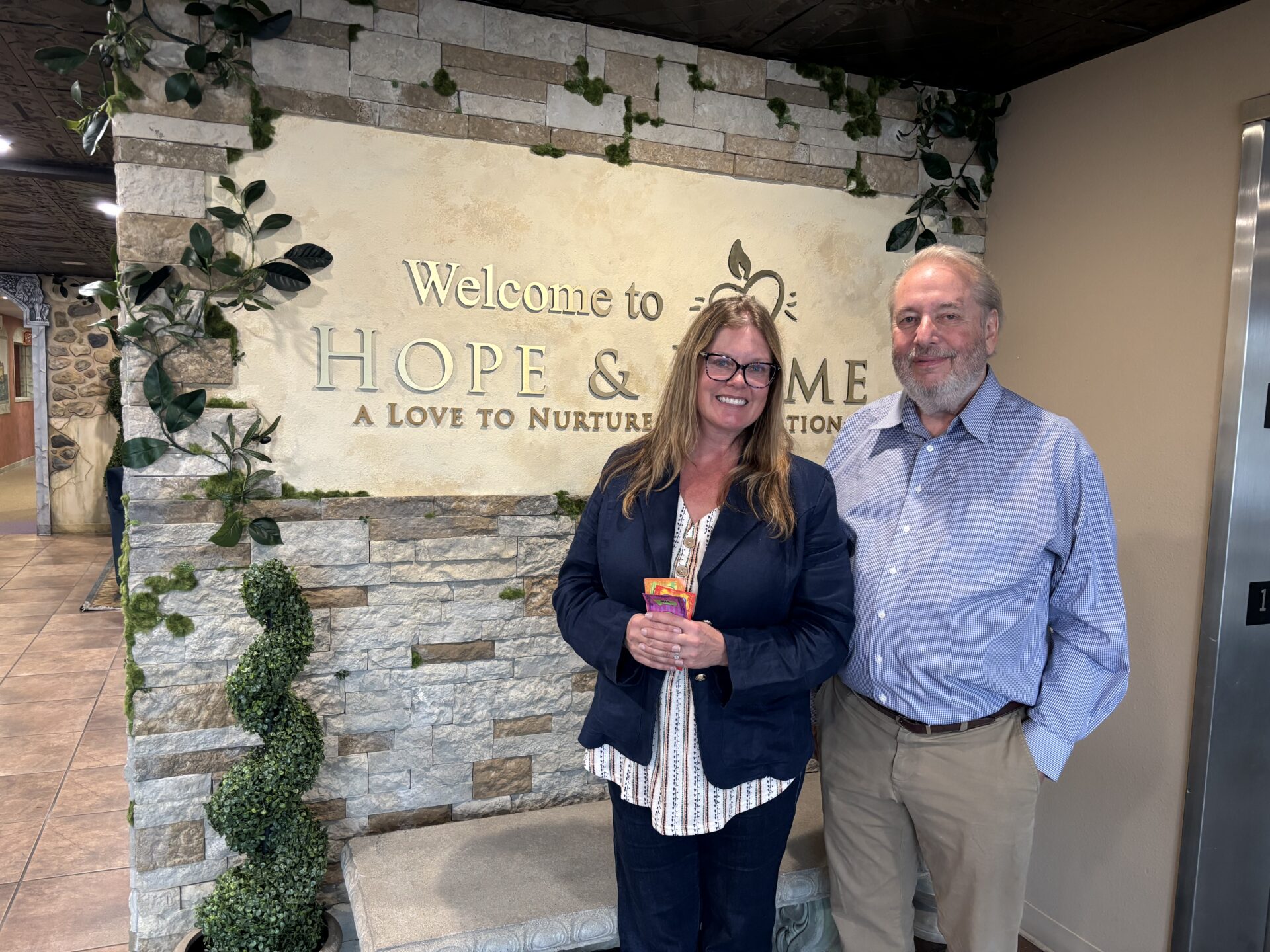 Hope and Home director Ross Wright with Clinical Director Jacque Thurman pose in front of the Hope and Home sign.