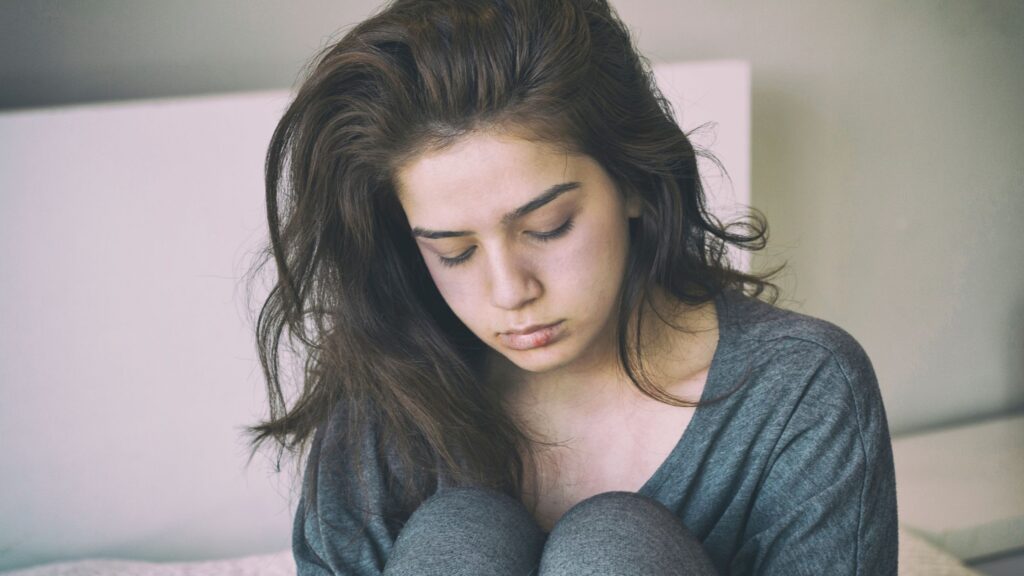 A young woman looking down with a sad face
