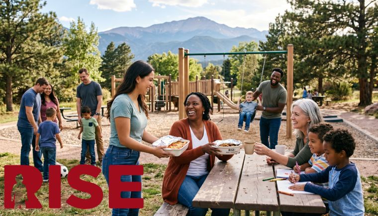 A scenic photo of diverse people at a mountain park. Foreground shows a mother receiving food and a grandmother with drawing children. Swings and pine trees fill the middle ground. Mount Pikes Peak in background.
