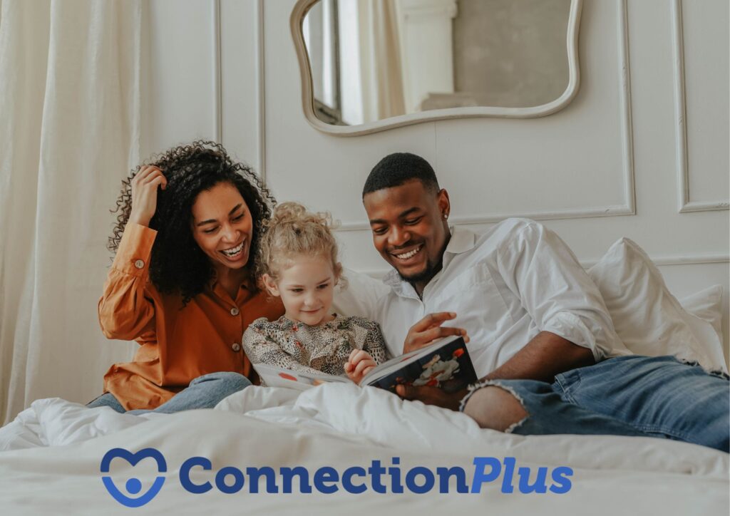 A smiling family of three sits in bed together, reading a book. Below them, a logo reads "ConnectionPlus" alongside a blue heart icon.